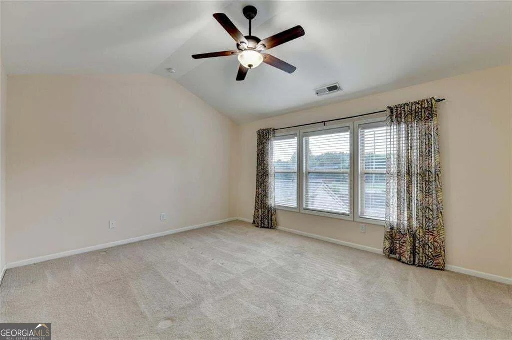 Primary bedroom with vaulted ceiling